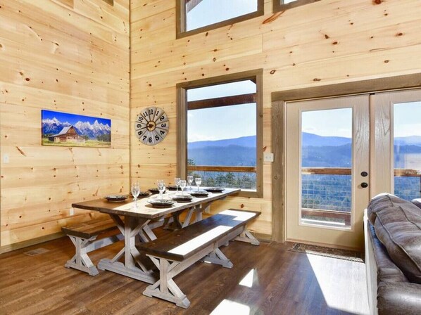 Enjoy meals with family and friends in the cabin's dining area, surrounded by a breathtaking mountain view.