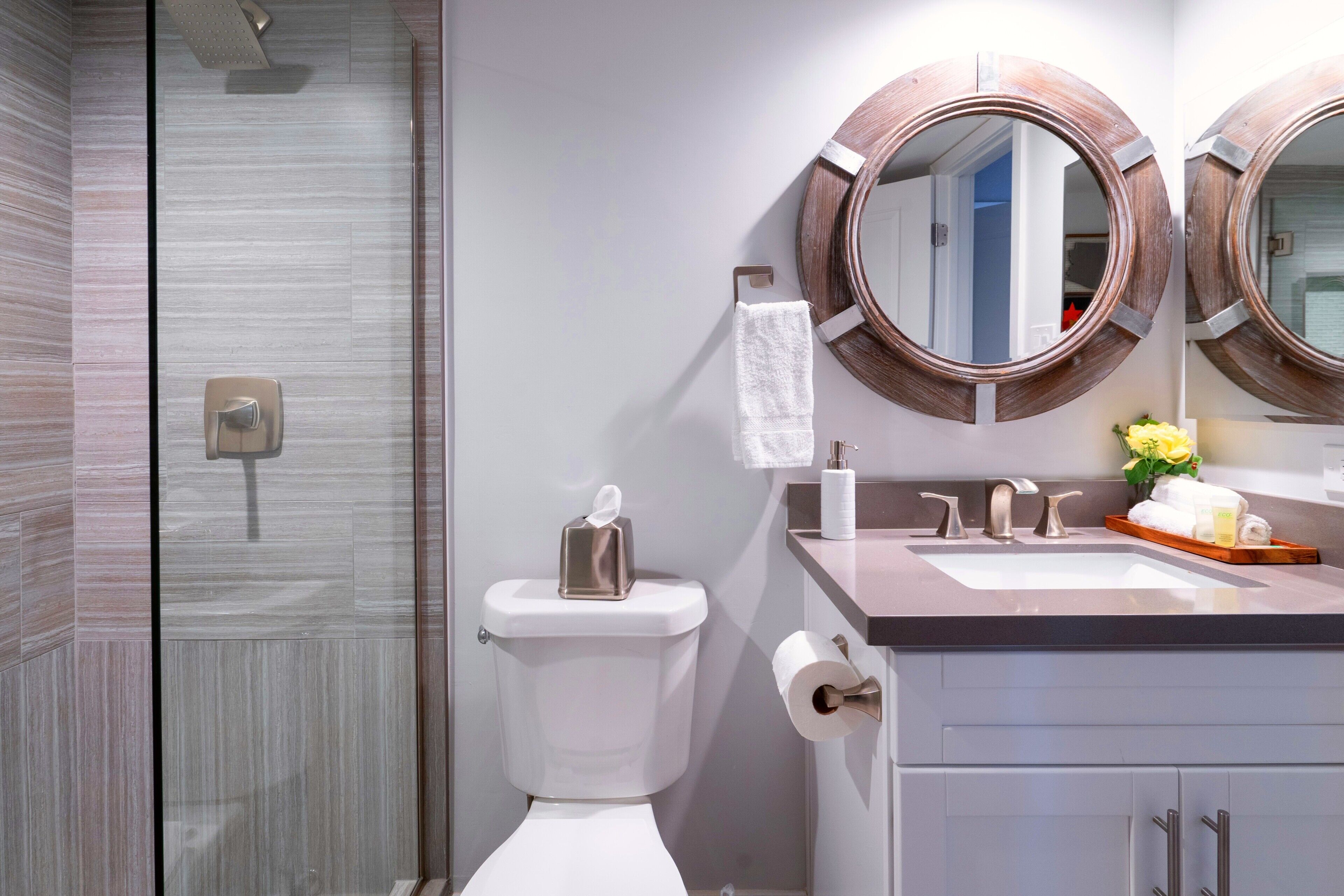 A modern bathroom with a shower, toilet, and vanity.