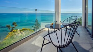 A balcony with a glass railing overlooking a clear blue sea and a distant coastline. - Sueño LUXURY VILLA 180 Iconic Sea View (Zakynthos)