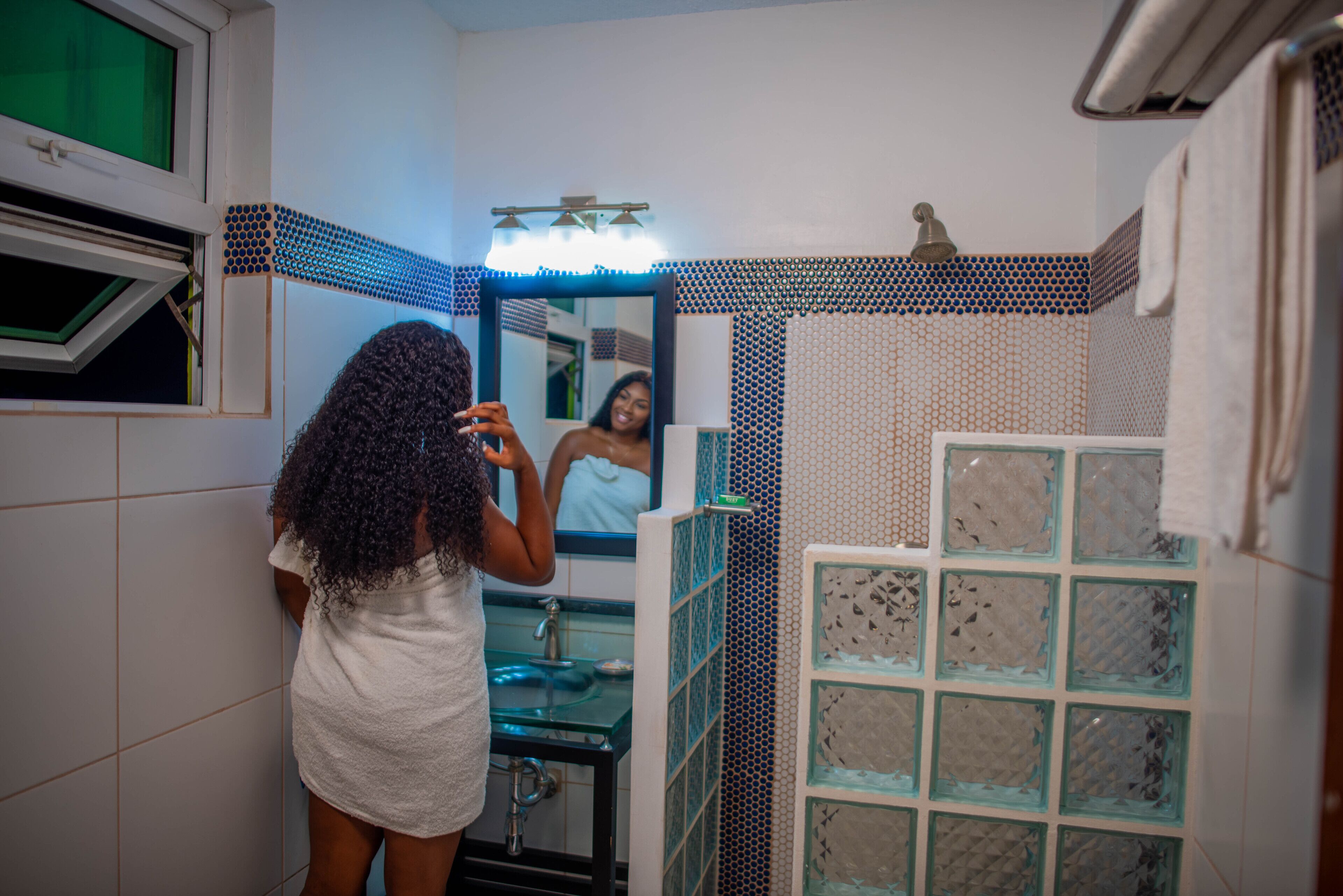 Un baño con espejo, lavabo y zona de ducha.