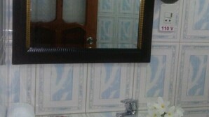 A bathroom with a mirror, sink, towel, and a power outlet. - Hostal Marisol y Marcos (Ciénaga de Zapata)