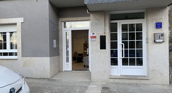 Entrada de un edificio con puerta, ventana y un letrero con el nombre de un negocio.
