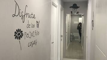 Un couloir avec un mur recouvert de miroirs, une enseigne décorative et une personne prenant une photo.