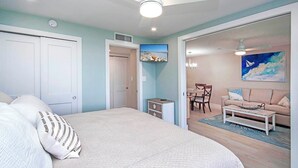 Un dormitorio con cama, escritorio, silla y una zona de comedor con mesa y sillas.