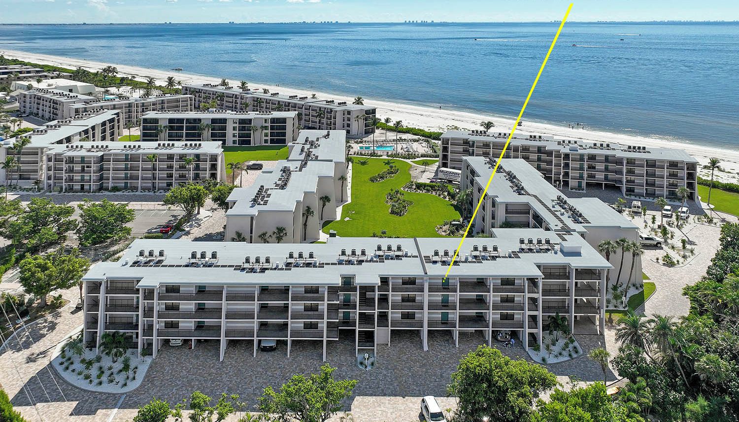 Un resort con varias construcciones, una piscina y vistas a la playa.