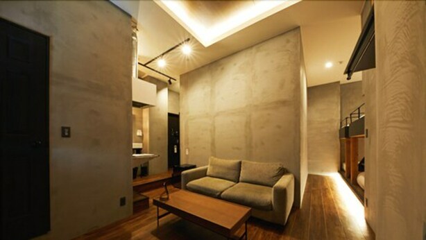 A modern living room with a wooden floor, a sofa, a coffee table, and a ceiling light fixture. - mizuka Nakasu 1 - unmanned hotel - (Fukuoka)