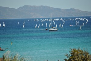 En la playa, arena blanca, sillas reclinables de playa, sombrillas
