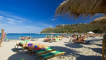 Am Strand, weißer Sandstrand, Liegestühle, Sonnenschirme