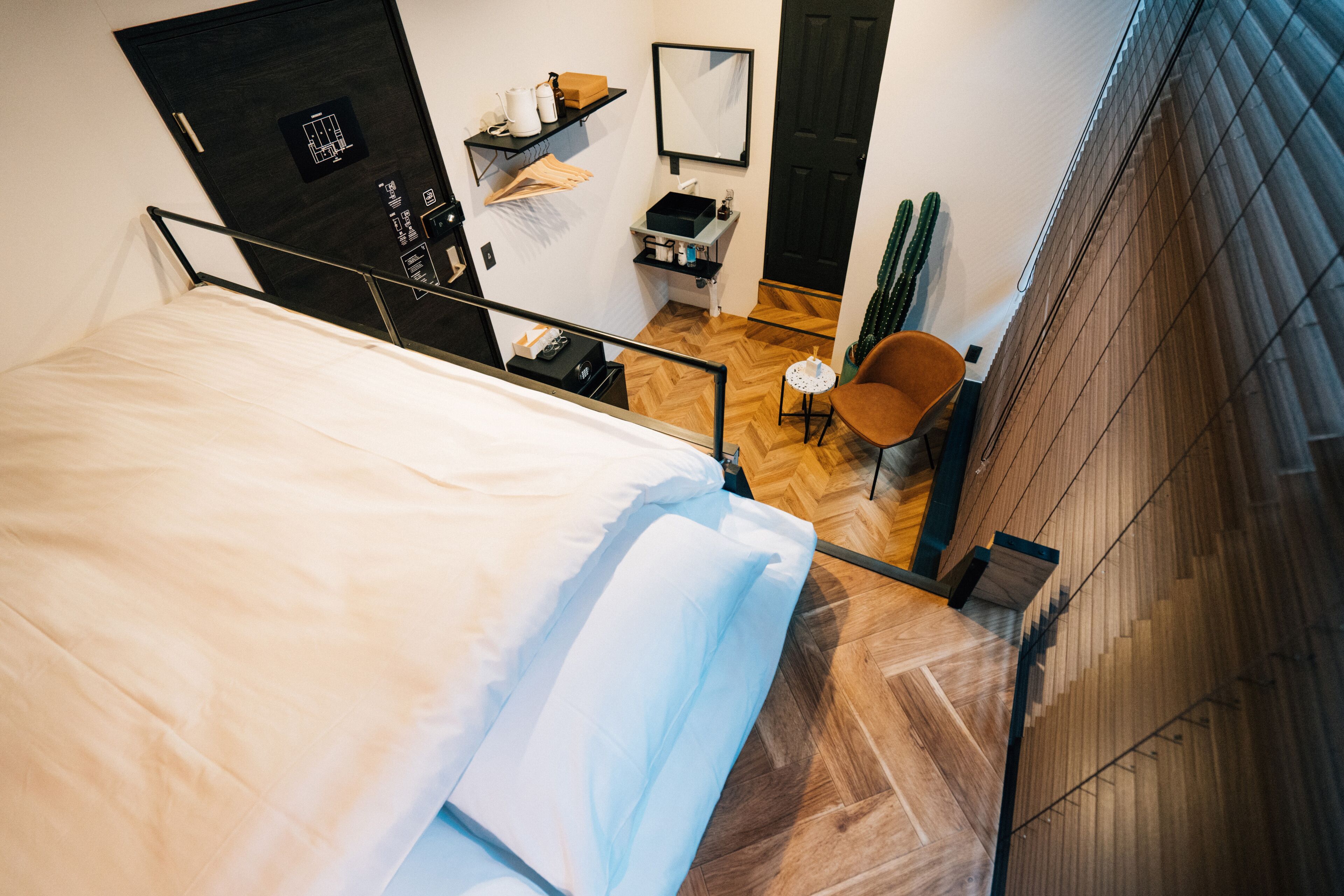 Una camera da letto con un letto, una sedia, una scrivania e uno specchio.