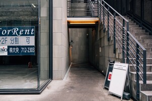 Un pasillo con un cartel de ForRent, una escalera y un letrero del café Corso Roy.