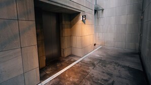 Een liftinterieur met een bord dat de richting naar de eerste verdieping aangeeft.