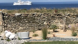A stone wall with a garden in front, a white boat in the background, and a clear view of the sea. - Le Clos de la Pointe Saint-Mathieu, Breton villa **** 180 ° sea view 2-13 pax (Plougonvelin)