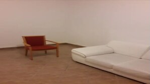 Ein Zimmer mit einem Holzstuhl und einem weißen Sofa.