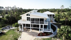 Une maison à deux étages dotée d’un balcon et d’un patio couvert.