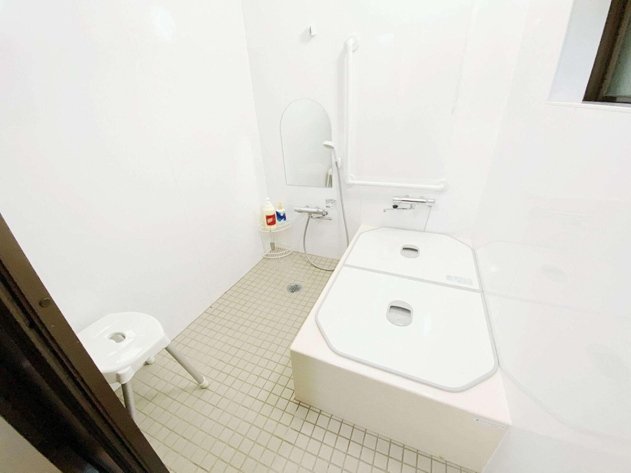 A small, white bathroom with a toilet, a sink, and a shower.