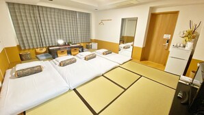 A hotel room with two beds, a small table, a mirror, a wardrobe, and a refrigerator. - Guesthouse 017 Reina (Tokushima)