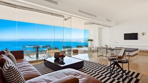 Ein modernes Wohnzimmer mit einer großen Glaswand, einem Sofa, einem Couchtisch und einem Fernseher.