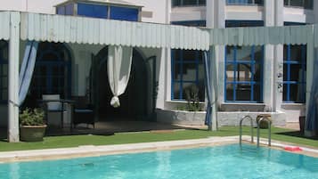 Utomhuspool, parasoller och solstolar
