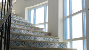 A spiral staircase with ornate blue and white tiles leading to a balcony. - Dar Salem (Mezraia)