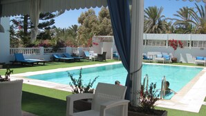 A pool area with lounge chairs and a covered seating area. - Dar Salem (Mezraia)