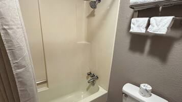 Un baño con bañera, inodoro y perchero para toallas.