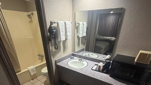 A modern bathroom with a vanity, two sinks, a mirror, a shower, and a toilet.