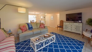A living room with a sofa, coffee table, and TV. - Cozy cottage in Gulf Gate to relax year-round in beautiful Sarasota. (Sarasota)
