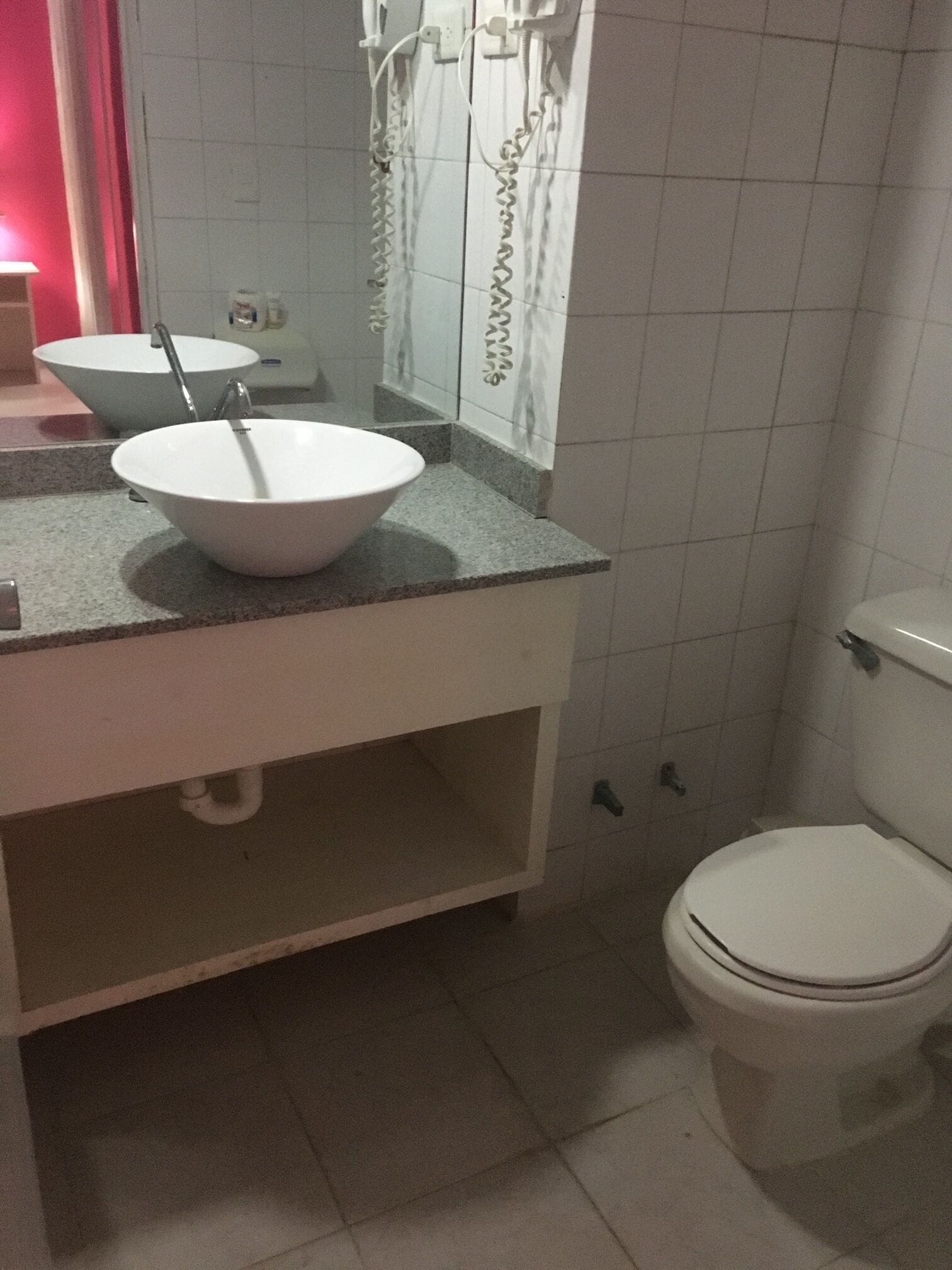 A bathroom with a white sink, a mirror, and a toilet.