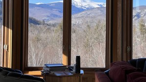 A room with a large window offering a mountain view. - Stunning views of Mt Washington and the presidentials. (Bartlett)