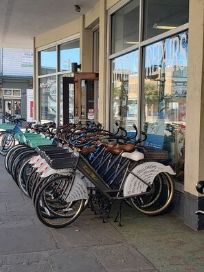 A row of bicycles parked outside a building with large windows and a sign that reads "REPAIRS". - The Marie is Ready to Host You and Yours  (North Charleston)