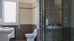 A modern bathroom with a shower, toilet, and sink.