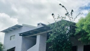 Un edificio moderno con techo plano, una ventana pequeña y una escalera que lleva a la entrada.