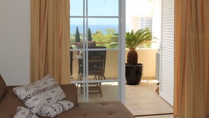 Una habitación con sofá, ventana grande y vistas al exterior.