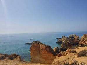A coastal landscape with rocky formations and clear blue sea. - Seaview apartment Alvor (Alvor)