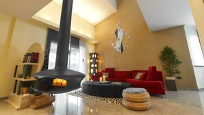 A modern living room with a fireplace, red sofa, and a wall clock.