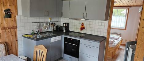 A compact kitchen with grey cabinets, a dishwasher, and a coffee maker.