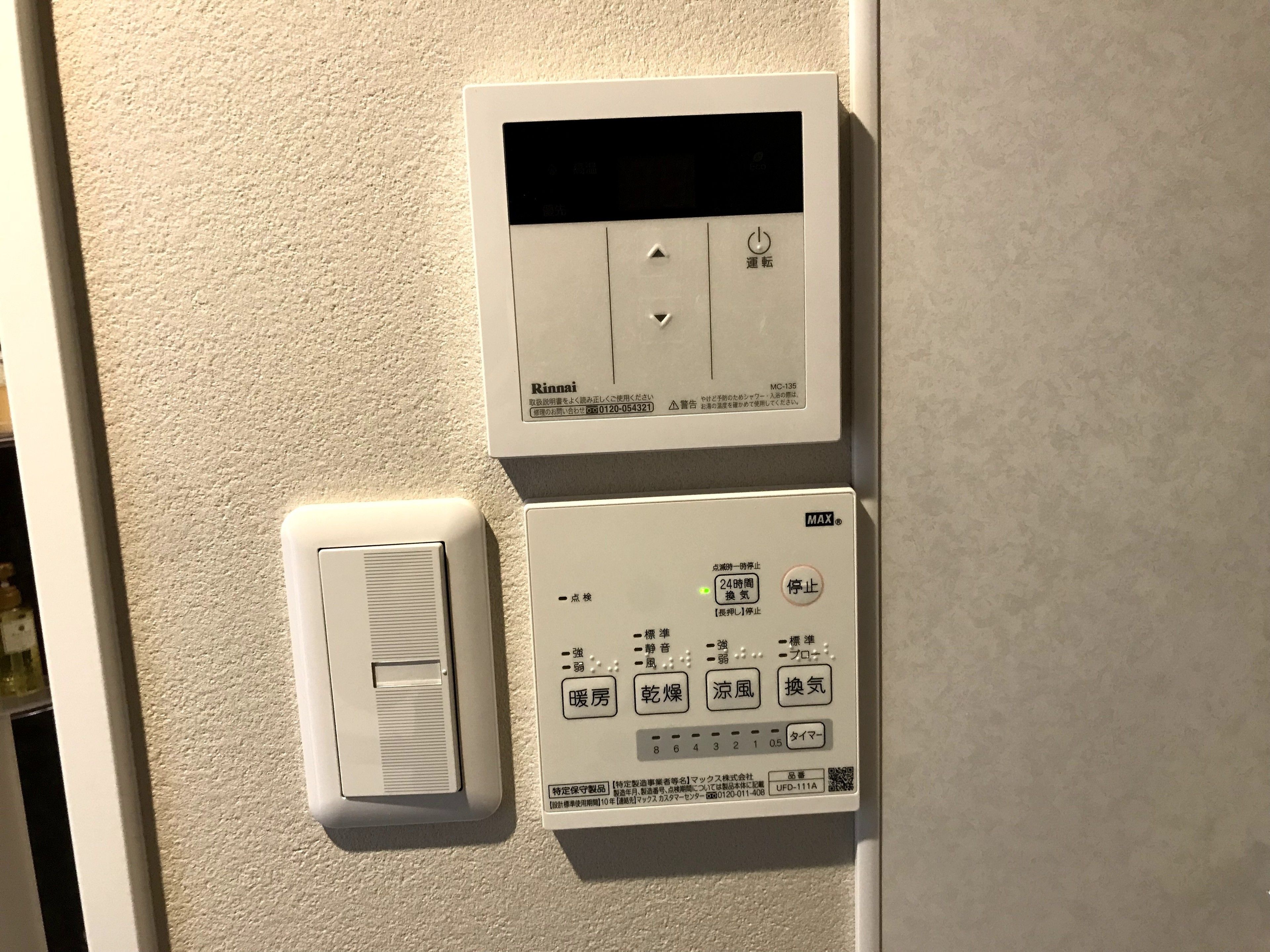 A thermostat and a control panel on a wall, with labels in a non-English language.