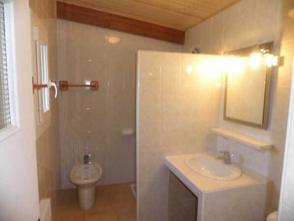 Un baño con inodoro, bidé y lavamanos.