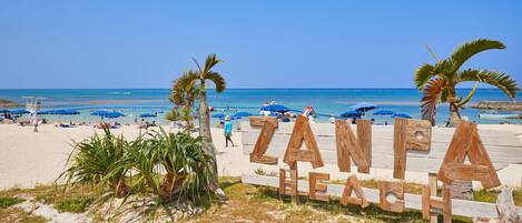 A beach with wooden signage reading "ZANFA BEACH".