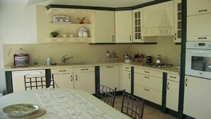 Cocina compacta con comedor, que incluye un lavamanos, cocina y armarios.