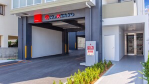 En modern entré till en byggnad med en skylt där det står ”Herr KINJO”.