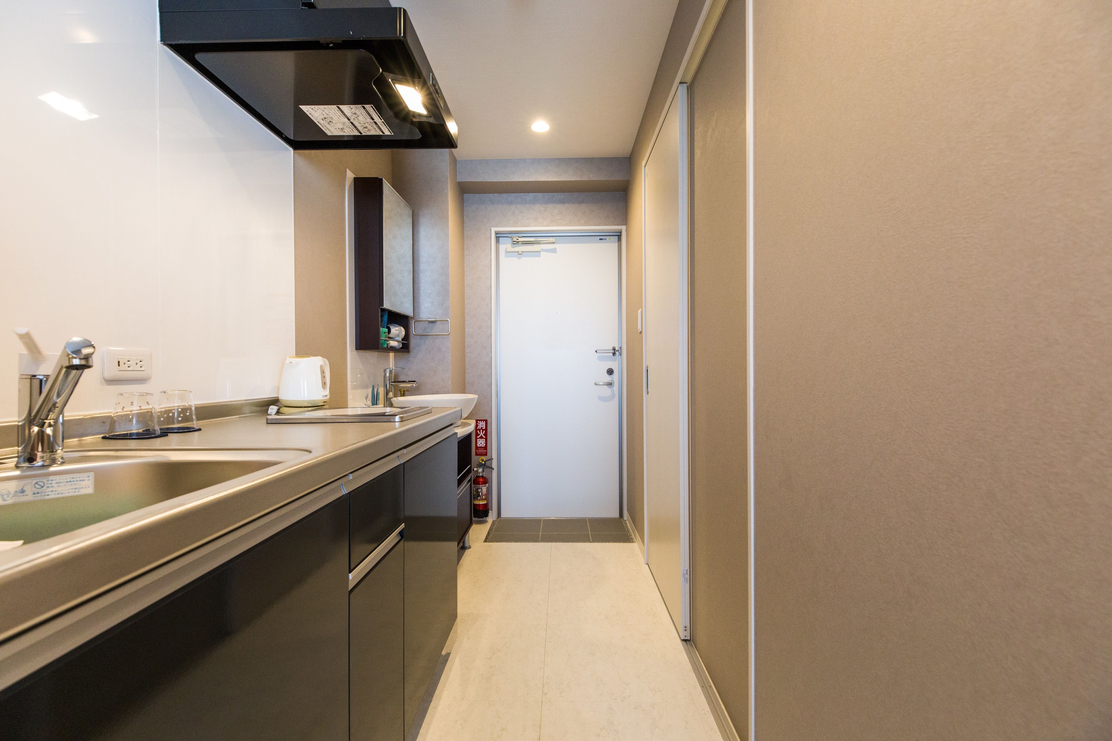A modern kitchen with stainless steel appliances, a double sink, and a countertop with a coffee maker.