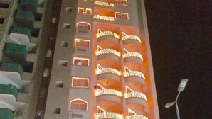 Un hotel de varios pisos con balcones y señalización iluminada.