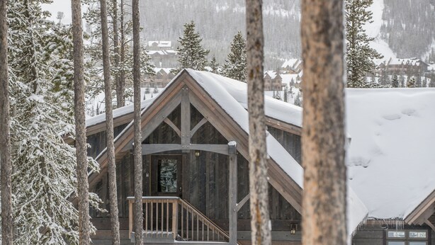 A wooden cabin with a balcony, surrounded by snow-covered trees. - Cozy ski-in/ski-out home w/fireplace & clawfoot tub - Little Plume Flat (Big Sky)