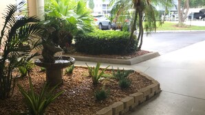 A covered outdoor area with a water feature, plants, and a paved walkway. - Welcome to Santa Maria 310, a little piece of Paradise! (Fort Myers Beach)