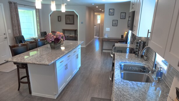 A modern kitchen with granite countertops, a central island, and a built-in sink. - Private House in Woodinville with Hot Tub, close to Wineries! (Woodinville)