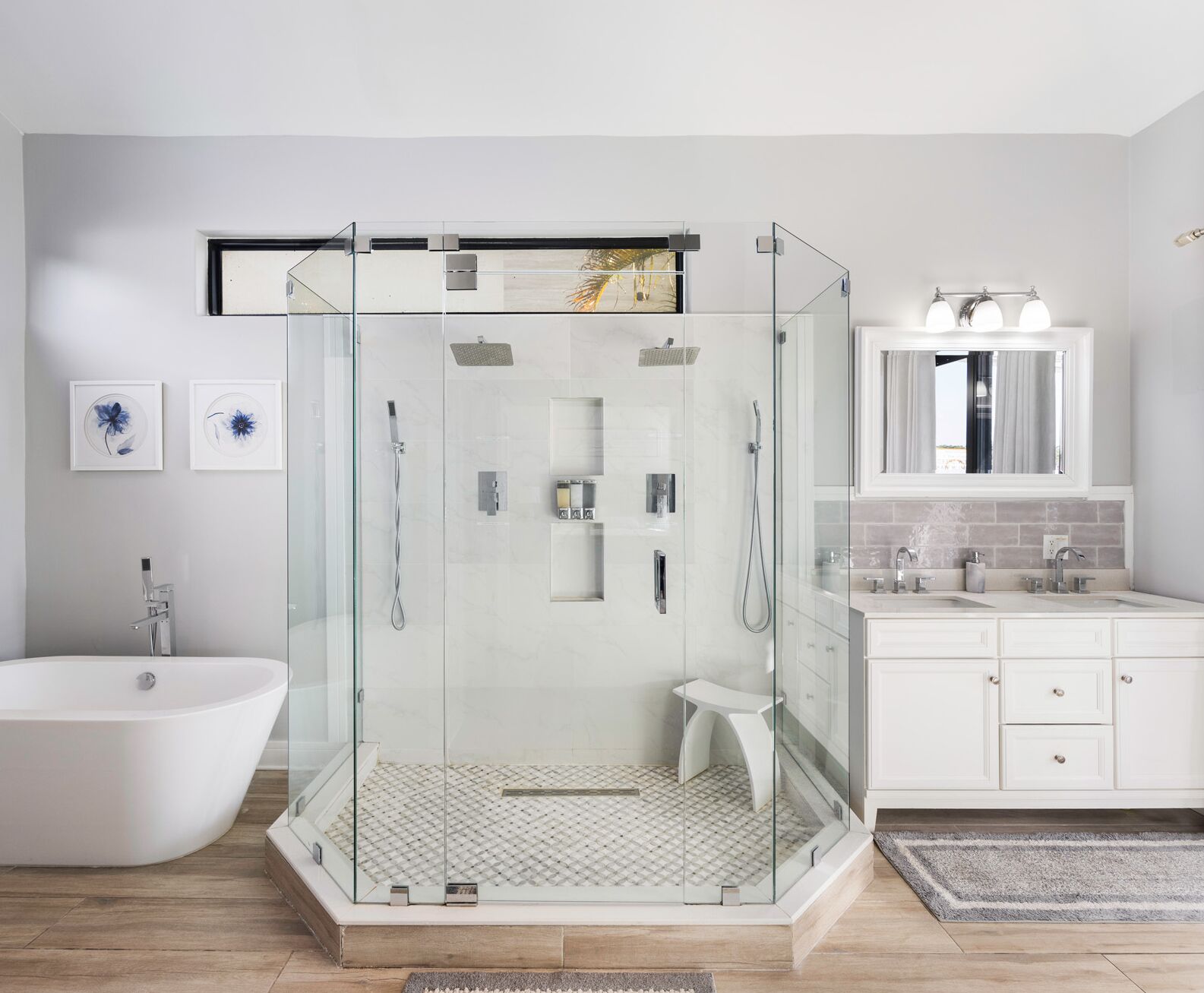 Un bagno moderno con doccia vetrata, una vasca freestanding e un mobile lavabo con specchio.