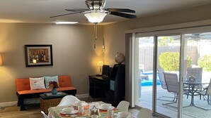 A dining area with a table set for four, a globe on a stand, and a view of a backyard patio with outdoor furniture. - FANTASTIC VACATION RETREAT!! HUGE POOL! CENTRALLY LOCATED-TONS OF EVENTS! (Tempe)