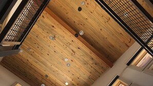 Eine hohe Decke mit Holzbalken und Oberlichtern, die natürliches Licht in den Raum lassen.