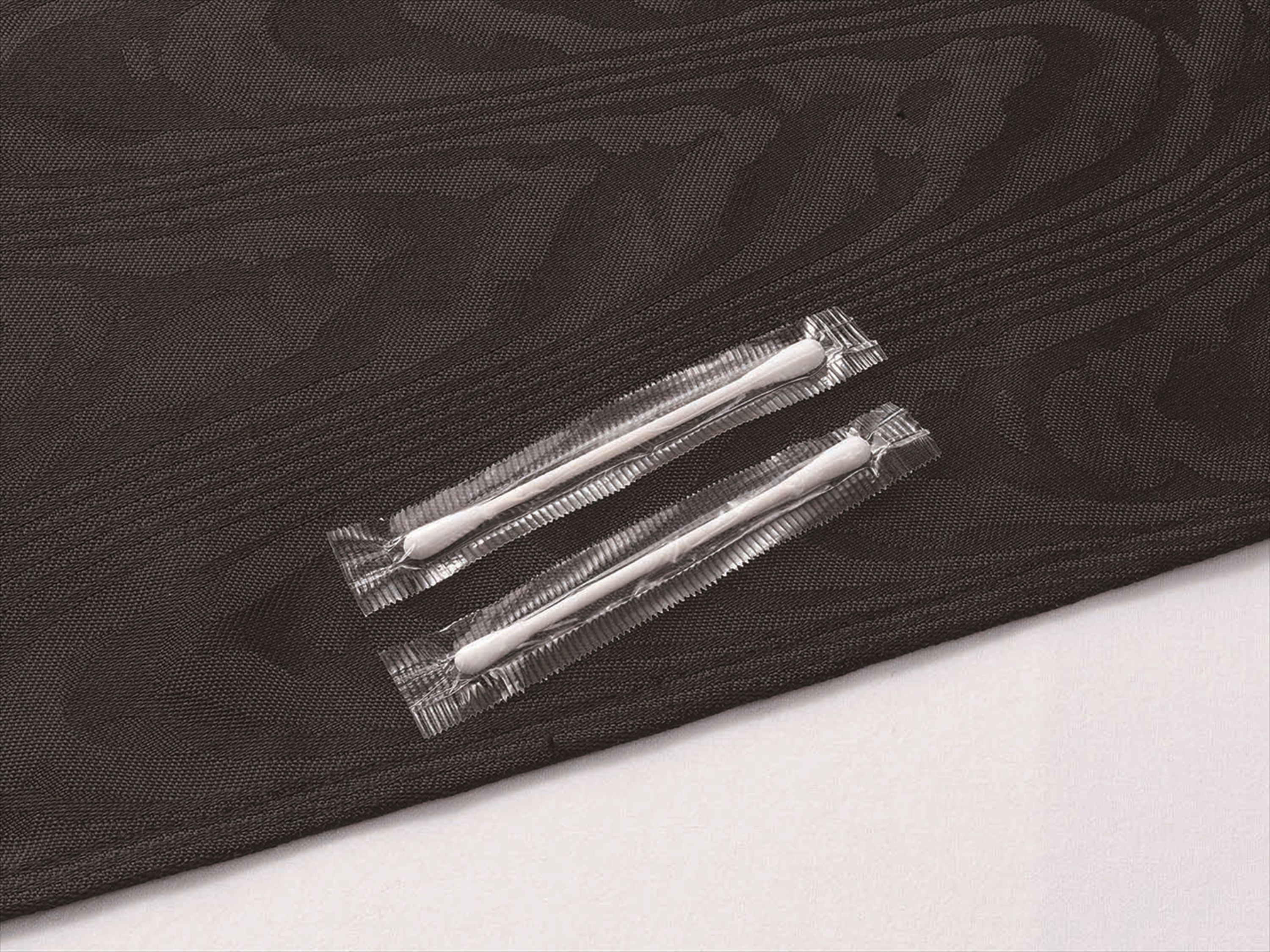 Primer plano de una tela oscura con dos cierres de plástico transparentes.